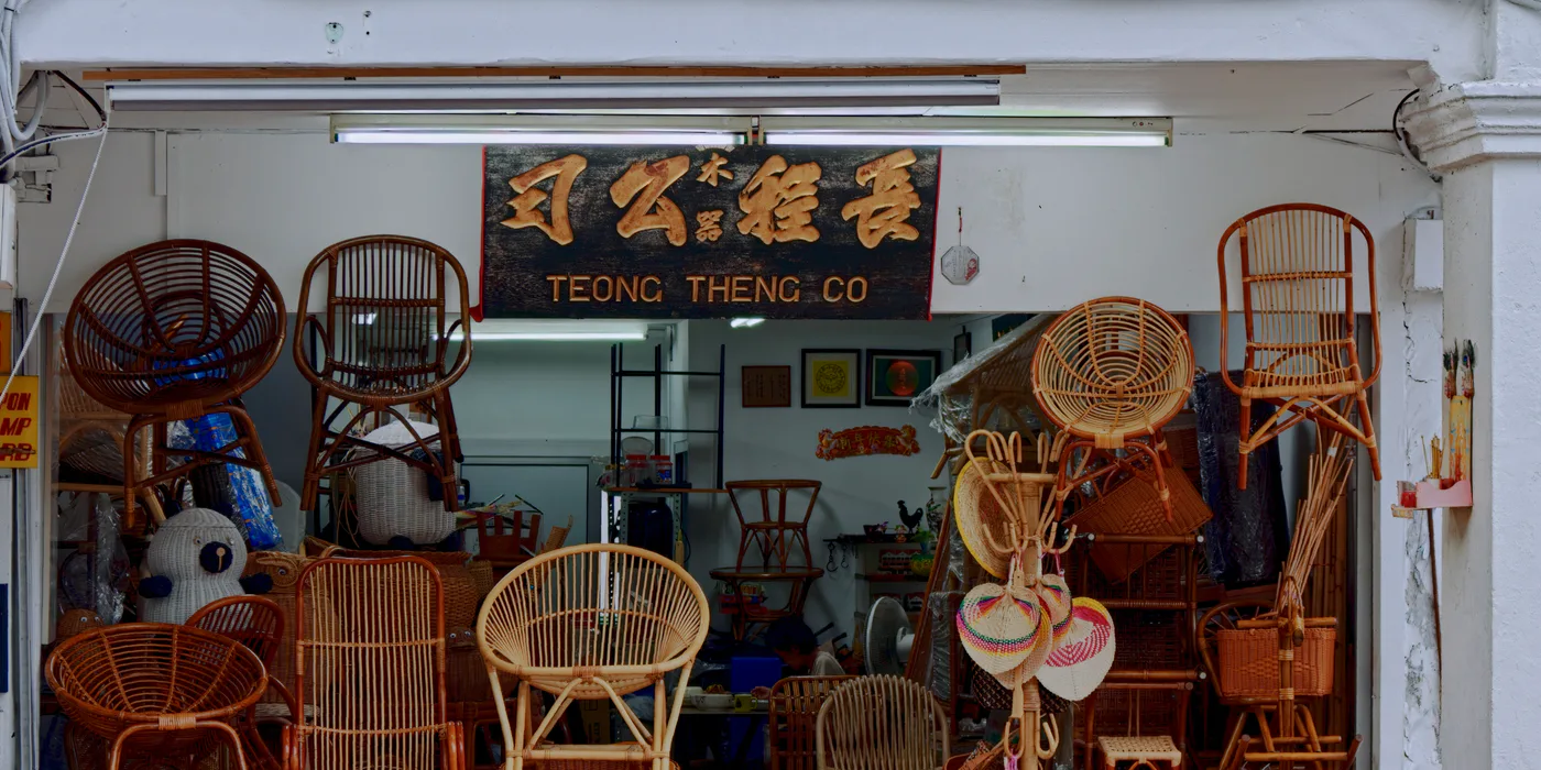 Traditional rattan furniture workshop filled with handcrafted chairs and baskets